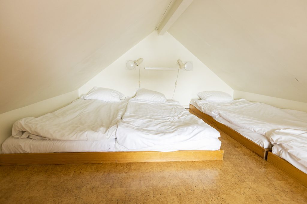 Tre stora sängar i en stuga.