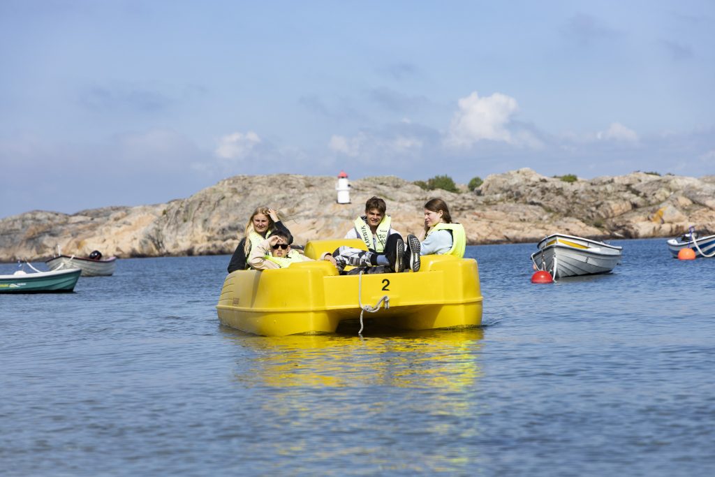 Fem ungdomar i en trampbåt på havet, en rolig aktivitet när ni är på klassresa på Ramsvik.