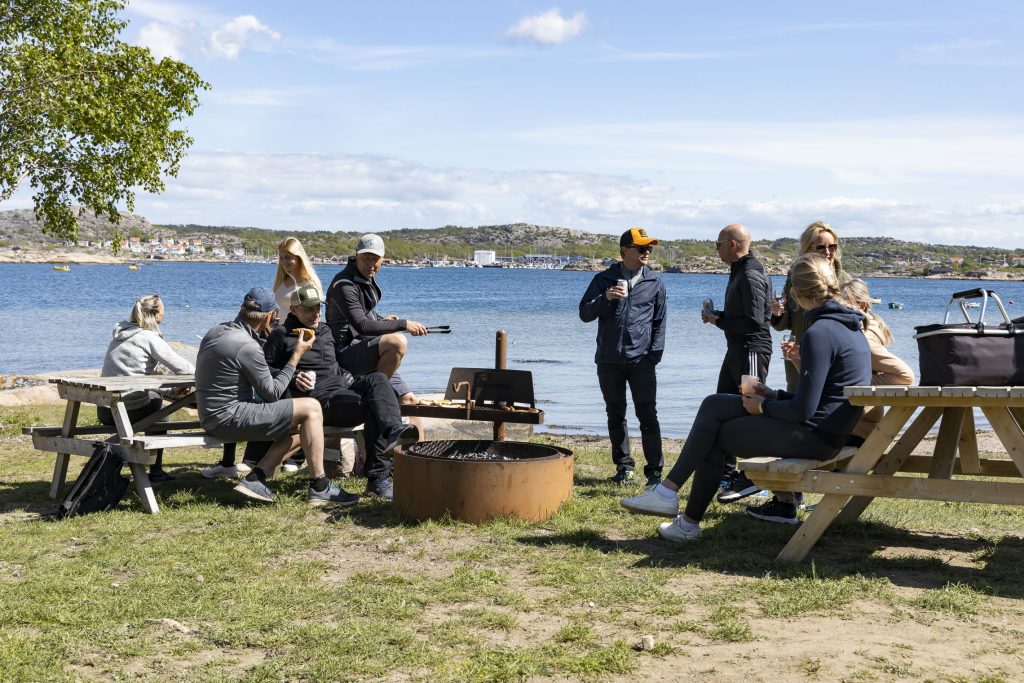 Flera familjer grillar tillsammans på grillplats vid havet på Ramsvik - en trevlig aktivitet på Kristi himmelsfärd