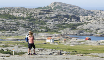 Ett par, som bokat vandringspaket på Ramsvik, tittar ut över hav och klippigt landskap i Ramsvikslandets naturreservat i Bohuslän.