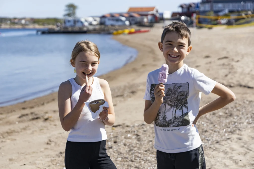 Två barn äter glass på Ramsviks strand. Boka ett semester paket på Ramsvik.