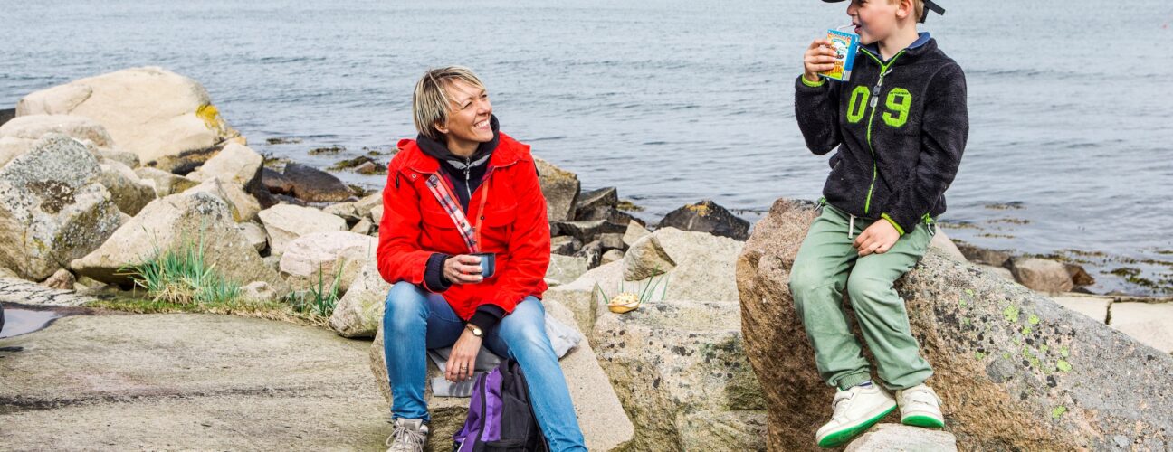 En pojke och en kvinna som sitter på klippor.