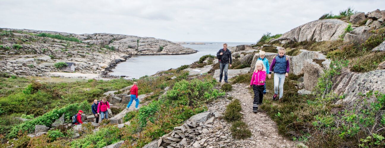 Ett gäng personer som vandrar längs med klippor.