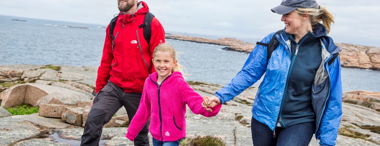 En glad familj som vandrar på klippor.