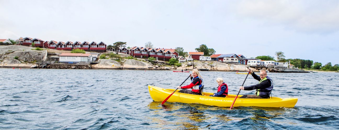 Familjekul med tre personer i en kanot.