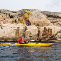 En man som paddlar kajak på Ramsvik, en outdoor-aktivitet där man får njuta av härligt friluftsliv