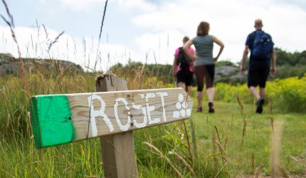 Närbild på en skylt som visar en vandringsled. Vandring i Bohuslän blir inte bättre än Ramsvikslandet.