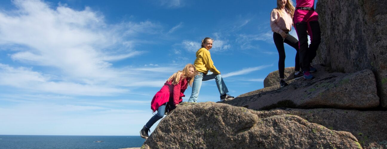 Vandrande familj på klippor.