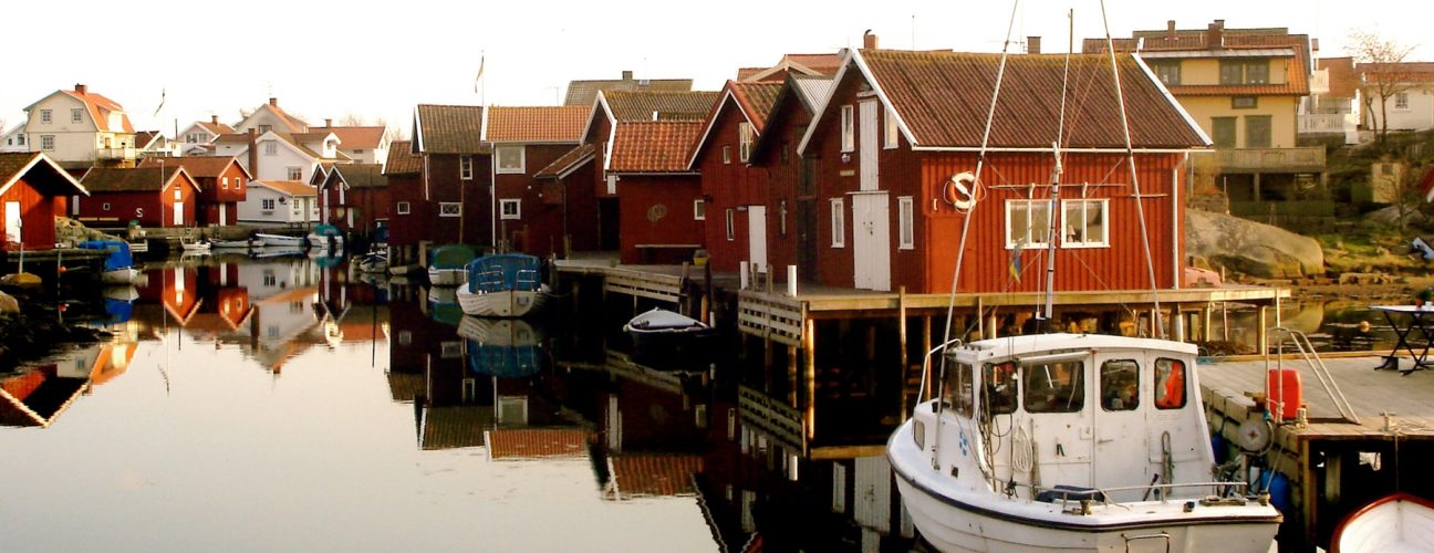 Överblicksbild på en brygga med röda campingstugor i Bohuslän.