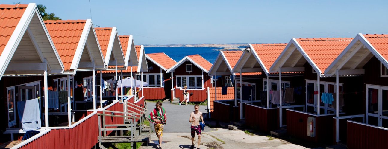 Överblicksbild på röda stugor som du/ni kan bo i vid en skolresa på Västkusten.