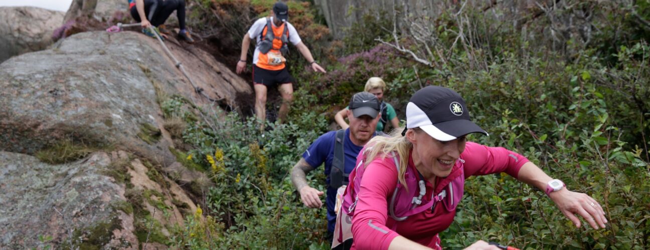 Ett gäng personer som utför trailrunning bland klippor och gräs.