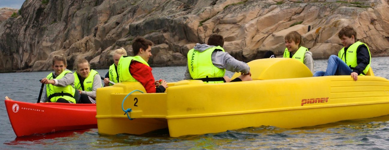 En gul trampbåt och en röd kanot ute på havet.